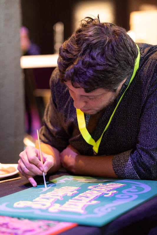 Gustavo Ferrari painting a sign stating “beyond tellerrand”