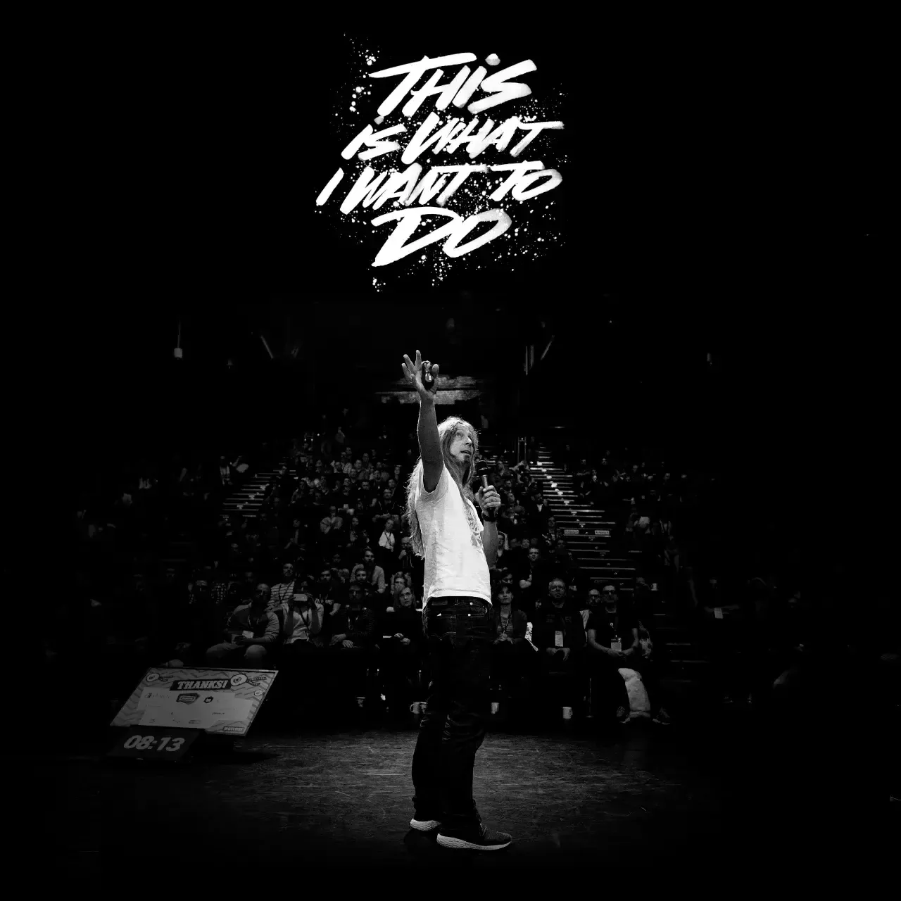 A squared image with a black and white photo. You can see Marc Thiele in the front and the audience of his event in the background. A white logo stating “This is what I want to do”, looking like being painted with a brush sits above Marc.