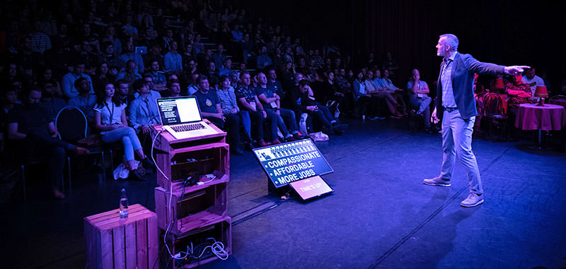 A photo showing Josh Clark opening the event in front of the audience