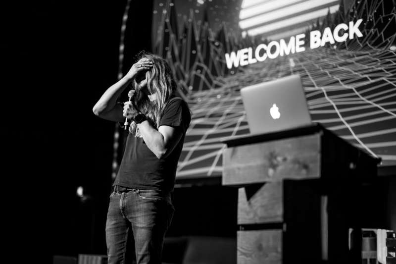 Marc Thiele opening beyond tellerrand in Düsseldorf on stage with tears in his eyes, covering his face with his hand