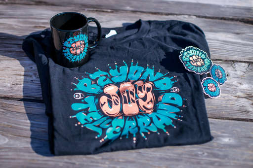 the design that Mark Caneso crafted on the event t-shirt is shown on a wooden table