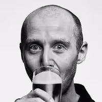 A photo with a portrait of Mike Hill drinking a beer