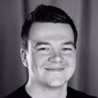 A portrait of Manuel ﻿Matuzović. He sits slightly tilted to the left and has a charming grin on his face.