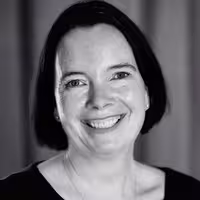 Portrait photo of Sacha Judd. She is looking into the camera and has a big smile on her face. Her head is lightly tilted to the left.